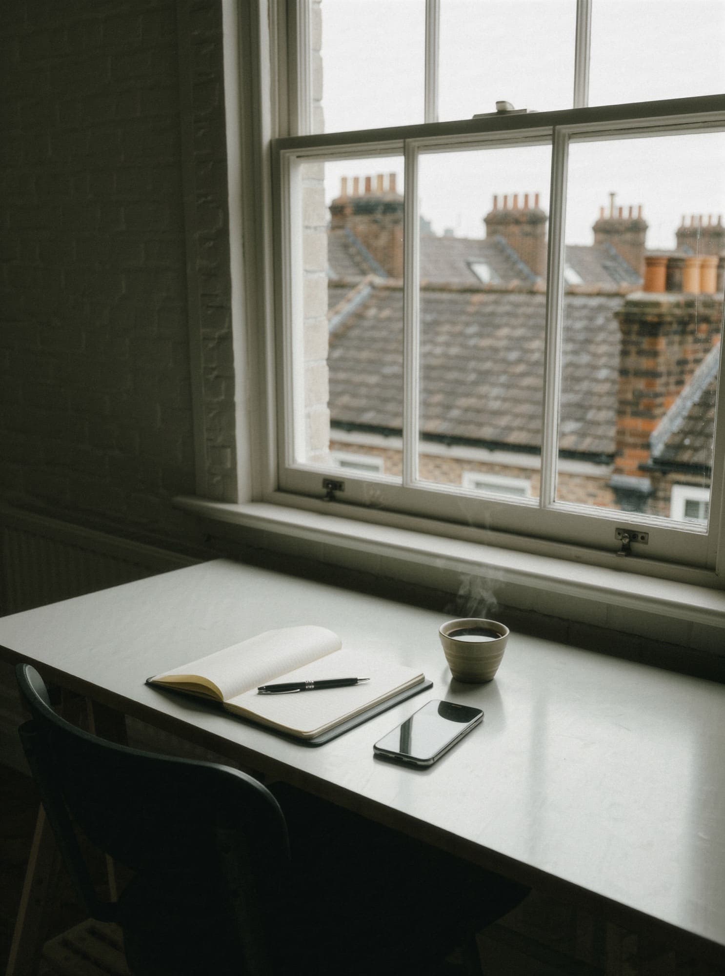 A studio desk by a window overlooking Sheffield rooftops